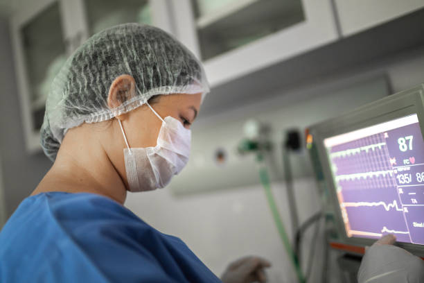ahli anestesi menonton monitor komputer pada operasi di rumah sakit - pengukur denyut nadi potret stok, foto, & gambar bebas royalti