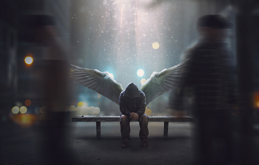 An angel sits on a bench as people pass by