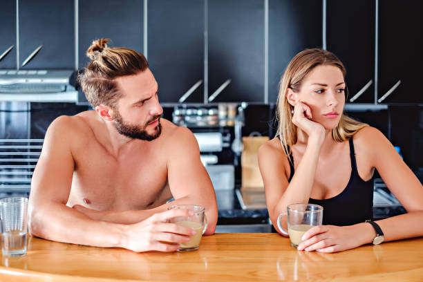 Angru couple sitting at the kitchen pult and holding coffee stock photo