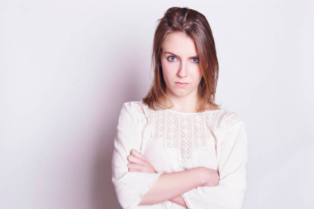 Angry blonde woman looking to the camera. Angry blonde woman looking to the camera. Indoors, over a white wall. gesturing stock pictures, royalty-free photos & images