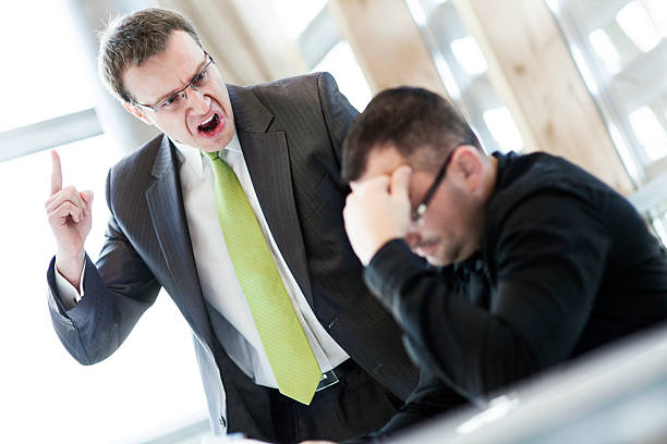 Angry businessman and his subordinate stock photo