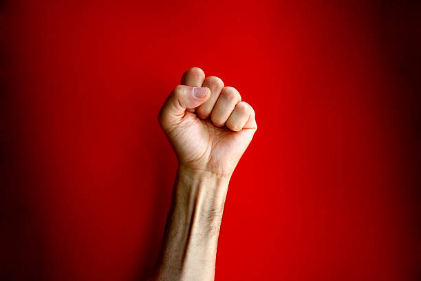 Angry clenched fist on red background stock photo