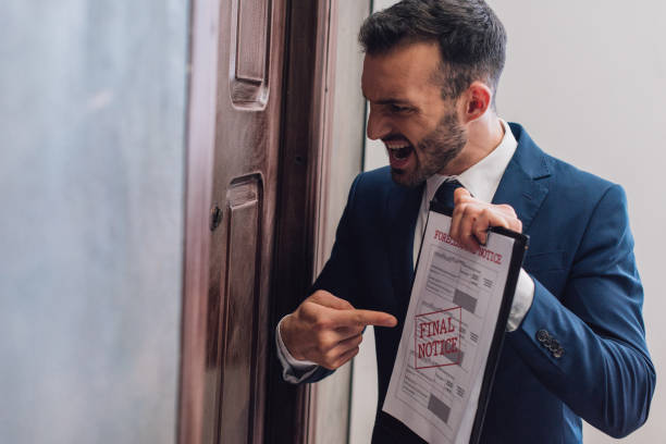Angry collector pointing at documents with foreclosure and final notice lettering and shouting near door Angry collector pointing at documents with foreclosure and final notice lettering and shouting near door collection stock pictures, royalty-free photos & images