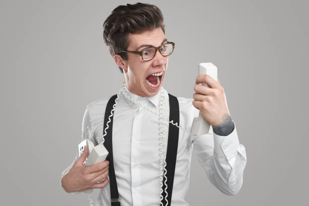 Angry employer screaming at phone stock photo