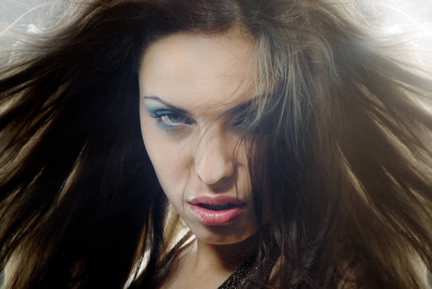 Angry female witch with wind blown hair stock photo