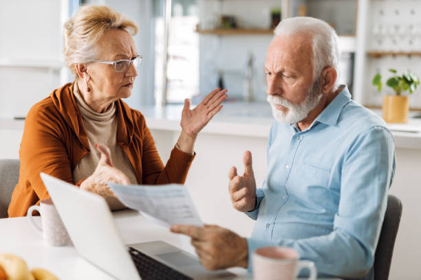 Angry mature couple arguing about their home finances at home stock photo
