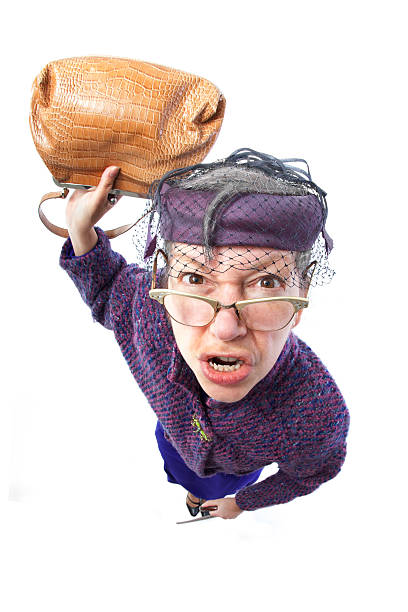 Angry old lady swinging a purse A fisheye shot of an angry old lady swinging a purse. ugly old women stock pictures, royalty-free photos & images
