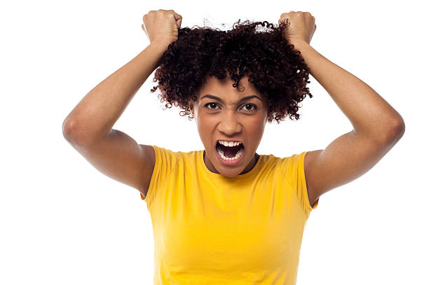 Angry young woman pulling her hair out stock photo