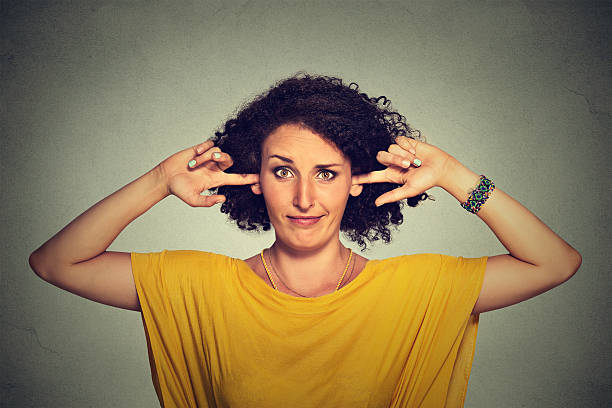 Annoyed woman plugging ears with fingers doesn't want to listen Annoyed upset angry woman plugging her ears with fingers doesn't want to listen ignoring stock pictures, royalty-free photos & images