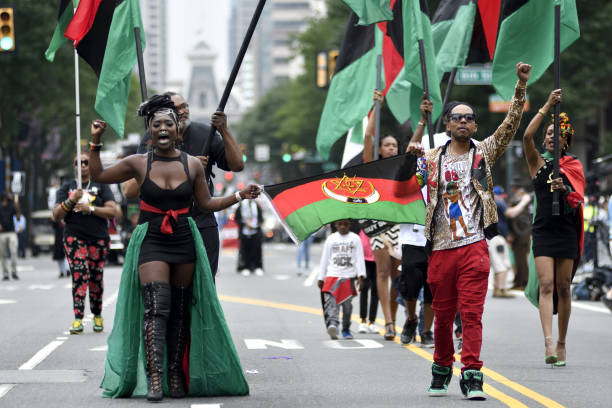 Philadelphia, PA, USA - June 23, 2018; Leighdy Morris, Queen of the RBG brigade (left) raises a fist as she marches over Market Street during the annual Juneteenth parade in Center City Philadelphia, PA, on June 23, 2018. The Juneteenth Independence Day or Freedom Day commemorates the announcement of abolition of slavery on June 19, 1865.
