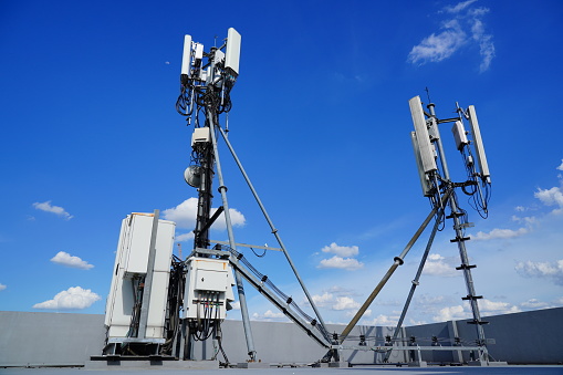 5G, 4G Antenna tower station  on roof in summer with blue sky background