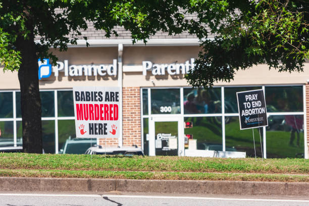 Anti Abortion Signs Planted In Front Of Planned Parenthood Clinic Lawrenceville, GA -  October 9:  Anti-abortion signs are planted in front of a Planned Parenthood clinic on October 9, 2021 in Lawrenceville, GA. abortion clinic stock pictures, royalty-free photos & images