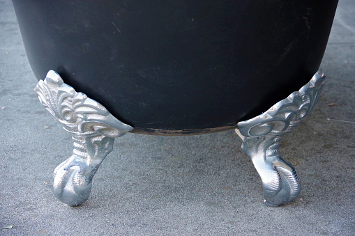 Close-up view of the decorative claw shaped feet of an old iron bathtub
