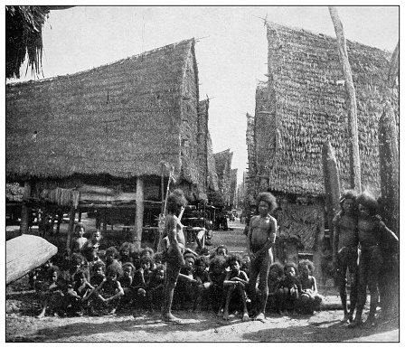Antique black and white photograph of people from islands in the Caribbean and in the Pacific Ocean; Cuba, Hawaii, Philippines and others: Papuan Village