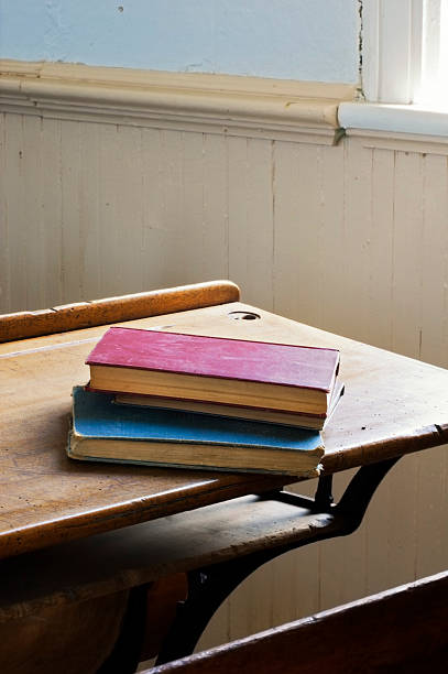 Antique Books Stacked on School Desk Dramatic Light stock photo