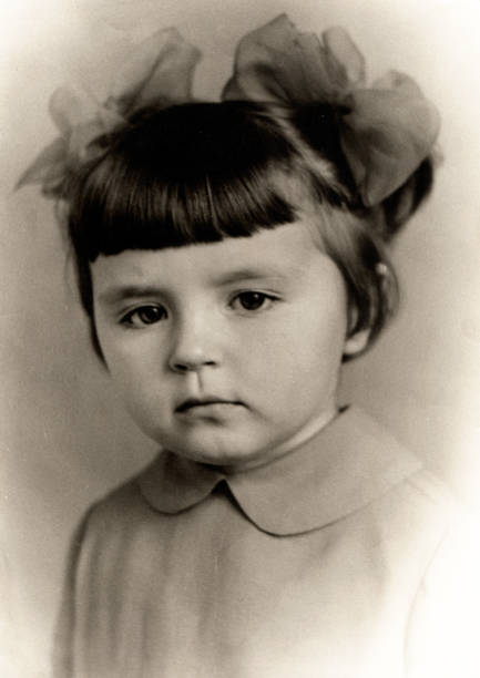 Antique photo show of a little girl with bows on her head. stock photo