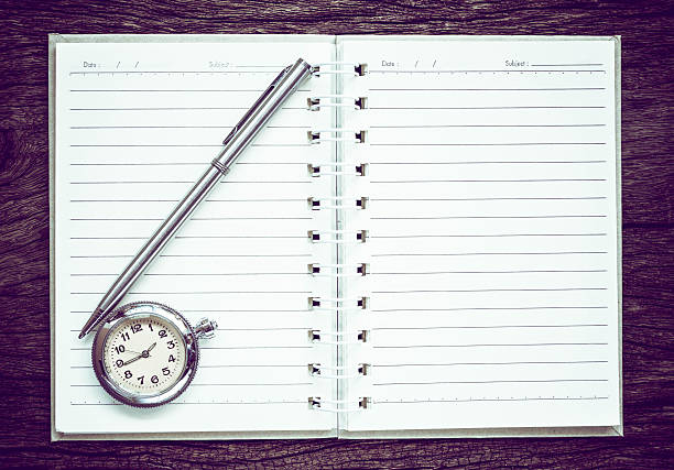 Antique pocket watch on notebook for notes, stock photo