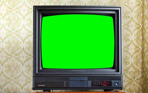 Antique TV with green screen on an antique wooden cabinet, old design in a house in the style of the 1980s and 1990s. Antique TV with green screen on an antique wooden cabinet, old design in a house in the style of the 1980s and 1990s. the past stock pictures, royalty-free photos & images