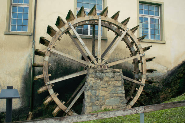 Antique wheel for pumping water. Used as a decor near the building. water wheel stock pictures, royalty-free photos & images