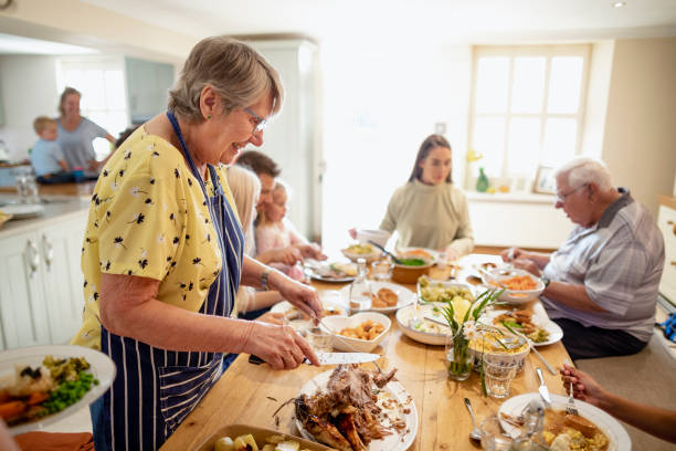 Anyone For Seconds? A side-view shot of a family ready to enjoy a roast dinner. roast dinner stock pictures, royalty-free photos & images