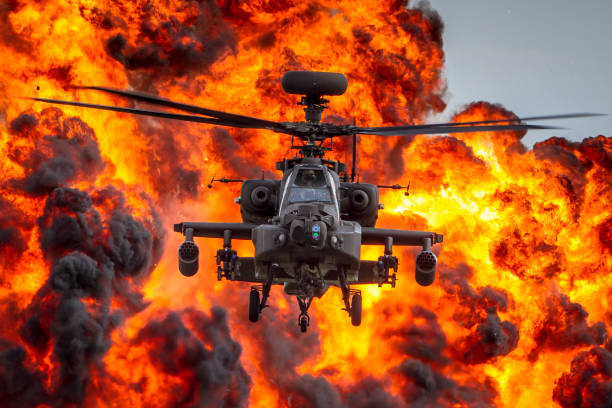 Apache Boom! British Army AH64 Apache attack helicopter flying from an explosion of flames and smoke military helicopter stock pictures, royalty-free photos & images