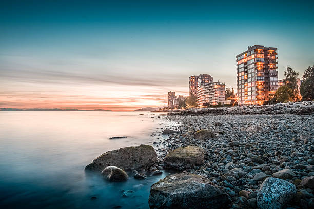 Apartment buildings on the coast at sunset Apartment buildings on the coast/beside sea/ocean at sunset, taken in West Vancouver, BC, Canada west vancouver stock pictures, royalty-free photos & images