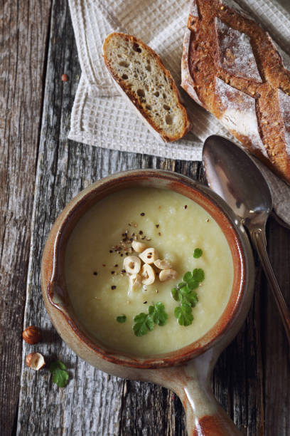 Apple celery cream soup with hazelnuts stock photo