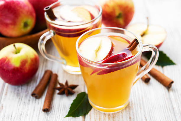 Apple cider  with cinnamon sticks Apple cider with cinnamon sticks on a old wooden table cider stock pictures, royalty-free photos & images