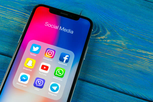 apple の iphone x ソーシャル メディア facebook instagram、twitter、snapchat アプリケーションの画面上のアイコンでオフィスの机の上。社会的なネットワーク。ソーシャル メディア アプリを起動しま� - sns ストックフォトと画像