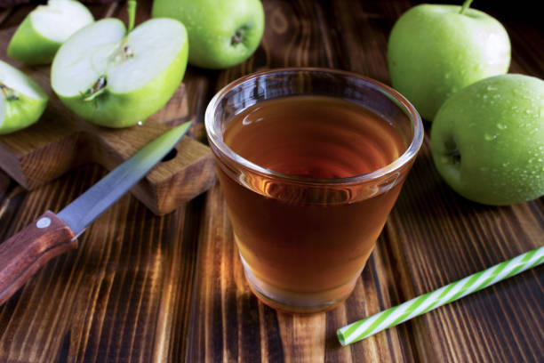 Apple  juice in thedrinking  glass on the wooden background. Close-up. stock photo