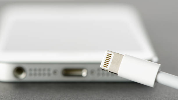 Apple Lightning Connector with iPhone 5 in Background stock photo