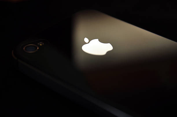 apple-logo mit iphone 4 und 4s, schwarzer hintergrund - apple computer stock-fotos und bilder