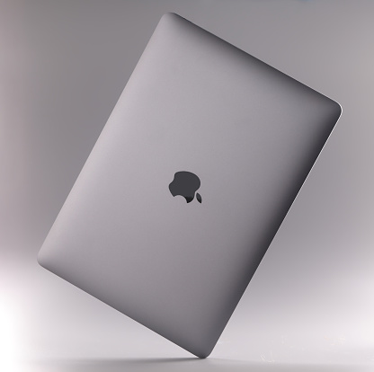 MINSK, BELARUS - DECEMBER 6, 2021: new digital laptop Apple MacBook air on gray background closeup. Sale of computer equipment and electronics concept
