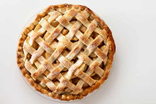 A lattice top apple pie on a light background.