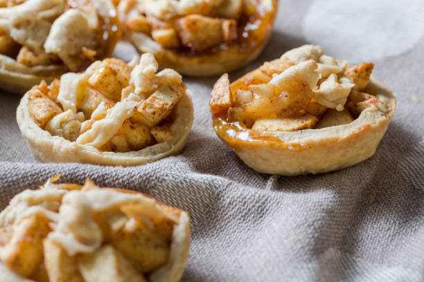 Apple pies on kitchen towel - mini apple tartlets Apple pies on kitchen towel - mini apple tartlets close up with selective focus tart dessert photos stock pictures, royalty-free photos & images