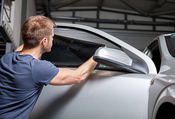 applying tinting foil on a car window - car wrap stockfoto's en -beelden