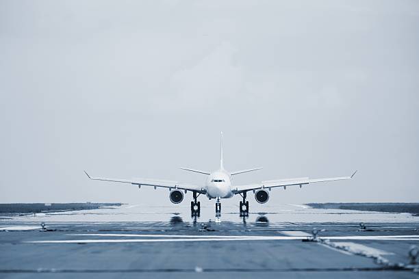Approaching airplane as seen from a runway Airplane is landing on the airport  airfield photos stock pictures, royalty-free photos & images