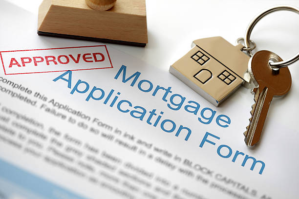 Approved mortgage application Approved Mortgage loan application with house key and rubber stamp mortgages and loans stock pictures, royalty-free photos & images