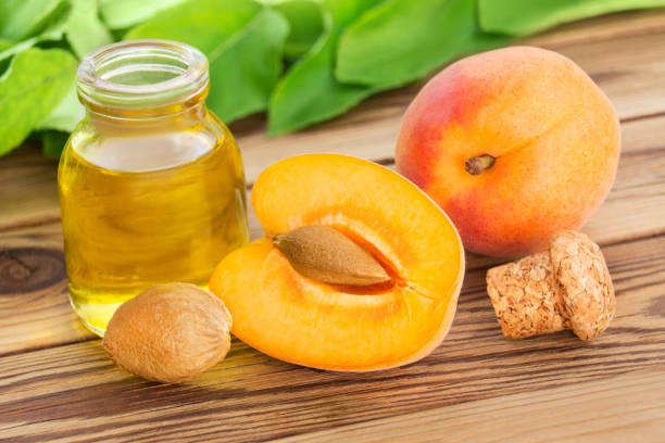 Apricot kernel oil on wooden background stock photo