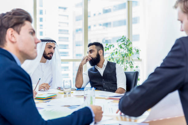 Arab businessman chairing a business meeting, while talking to his associate Corporate Business In The Middle East agal stock pictures, royalty-free photos & images