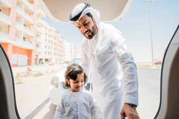 Arab dad looking inside the car's trunk with his son Arab dad looking inside the car's trunk with his son car trunk photos stock pictures, royalty-free photos & images