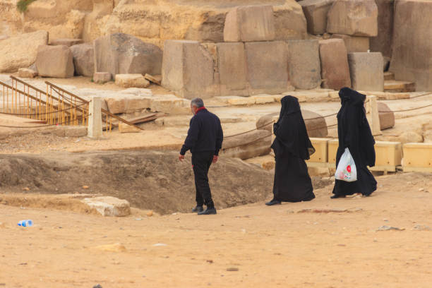 Arab with his two wives walking near Great pyramids of Giza in Cairo, Egypt Cairo, Egypt - December 8, 2018: Arab with his two wives walking near Great pyramids of Giza in Cairo, Egypt hot middle eastern girls stock pictures, royalty-free photos & images
