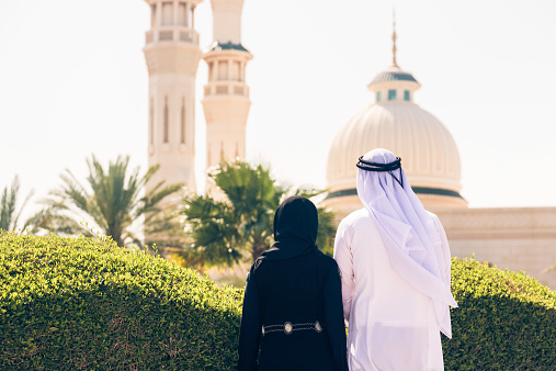 arabian couple standing in front of a mosque