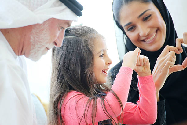 Arabian family making heart symbols with hands in a cafe stock photo