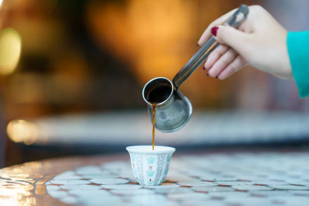 Arabic Coffee Hand pouring hot Arabic Coffee into a cup hot arabian women stock pictures, royalty-free photos & images