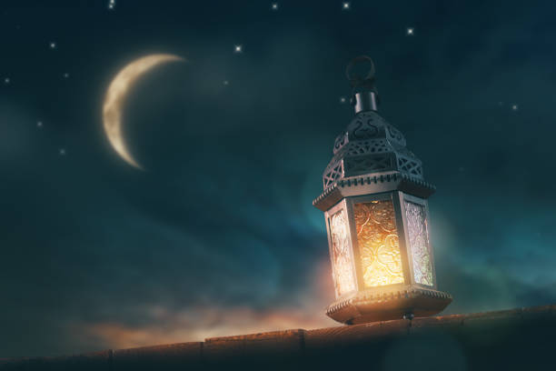 Arabic lantern with burning candle Ornamental Arabic lantern with burning candle glowing at night. Festive greeting card, invitation for Muslim holy month Ramadan Kareem. ramadan stock pictures, royalty-free photos & images