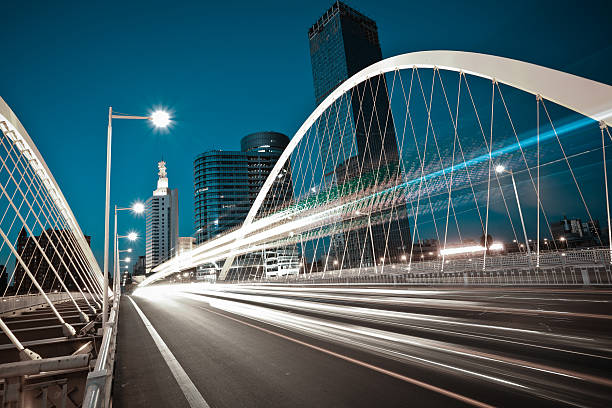 Arc bridge girder highway car light trails city night landscape stock photo