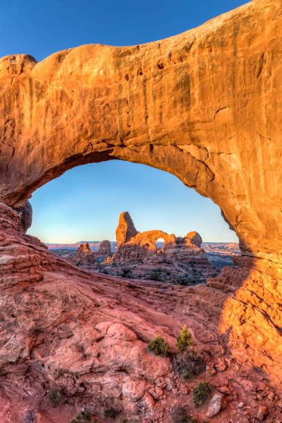 Arches within Arches Turret Arch at sunrise within the North Window natural arch in the Windows section of Arches national Park, near Moab, Utah arches national park stock pictures, royalty-free photos & images