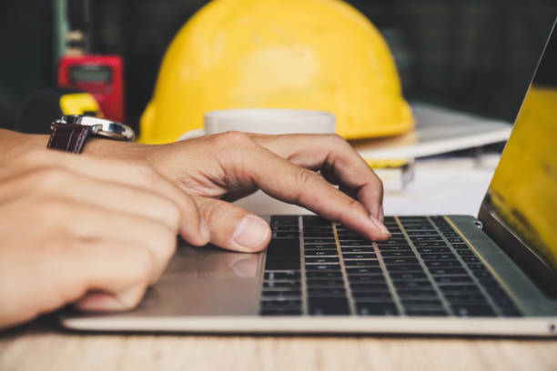 architect man working with laptop and blueprints : sketching a construction project ,engineer inspection in workplace for architectural plan, selective focus, Business concept vintage color. stock photo