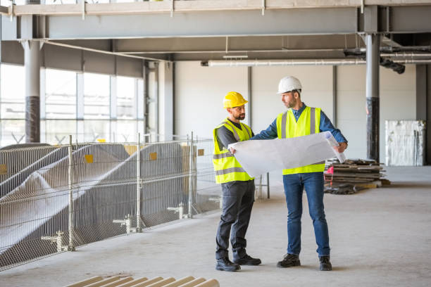Architect talking with builder at construcion site stock photo